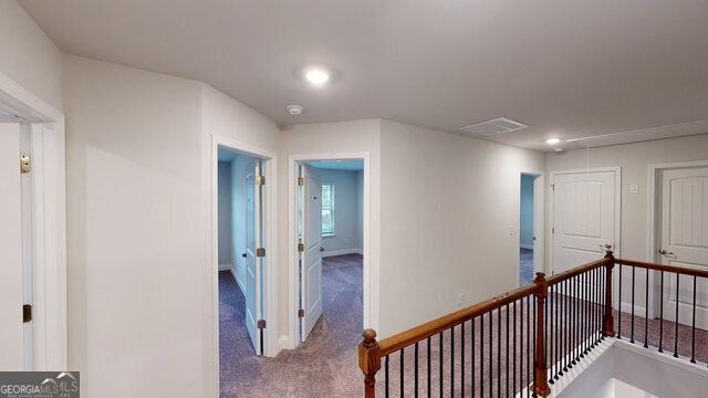 corridor with recessed lighting, baseboards, an upstairs landing, and carpet floors