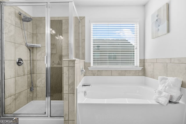 full bath featuring a shower stall and a garden tub