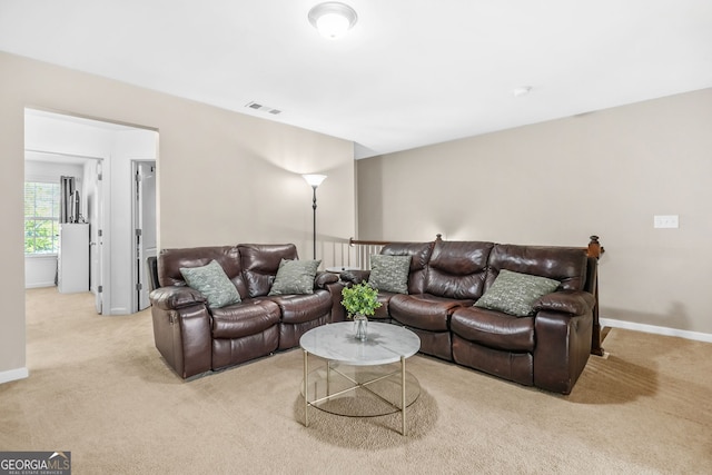 living area featuring visible vents, baseboards, and light colored carpet
