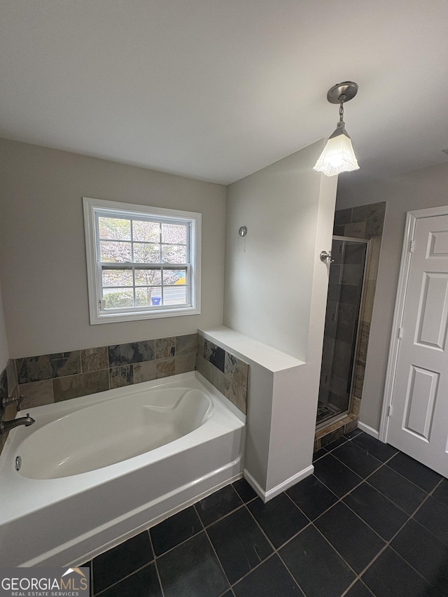 bathroom featuring tile patterned flooring, baseboards, a garden tub, and a stall shower
