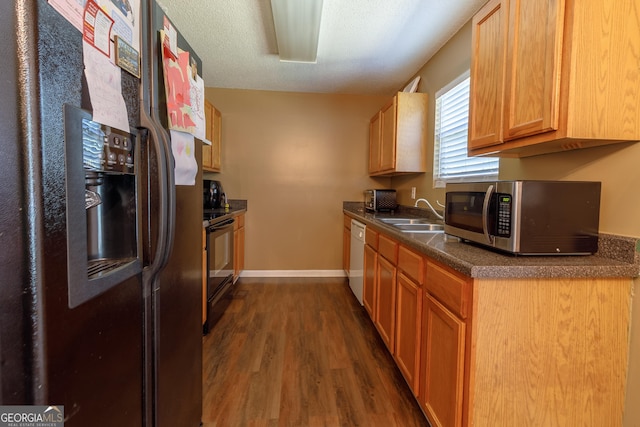 kitchen with stainless steel microwave, fridge with ice dispenser, black / electric stove, dishwasher, and a sink
