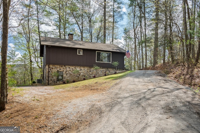 426 Crow Creek Rd, Lakemont, GA 30552 - view of home's exterior with stone siding, a chimney, a shingled roof, and asphalt driveway