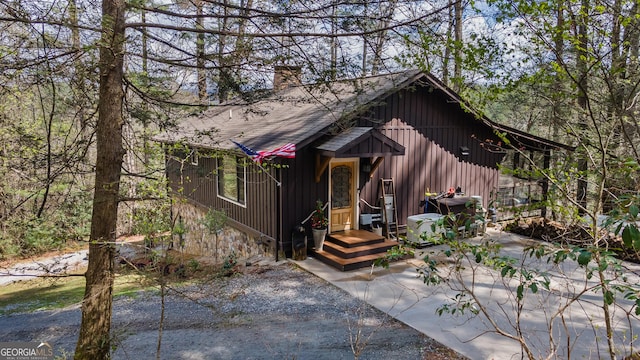 chalet / cabin with a shingled roof and a chimney