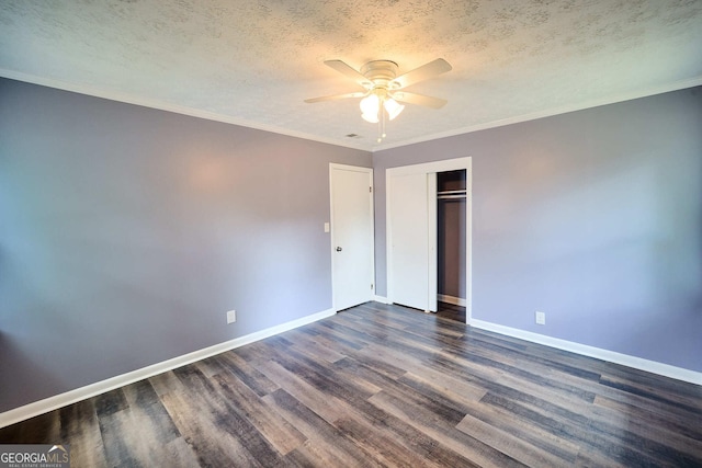 unfurnished bedroom with a textured ceiling, a closet, baseboards, and dark wood finished floors
