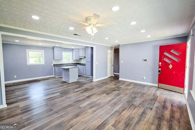 unfurnished living room featuring crown molding, ceiling fan, dark wood-style floors, and recessed lighting