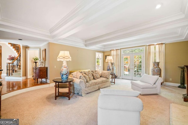 living room with a tray ceiling, ornamental molding, carpet, and stairs