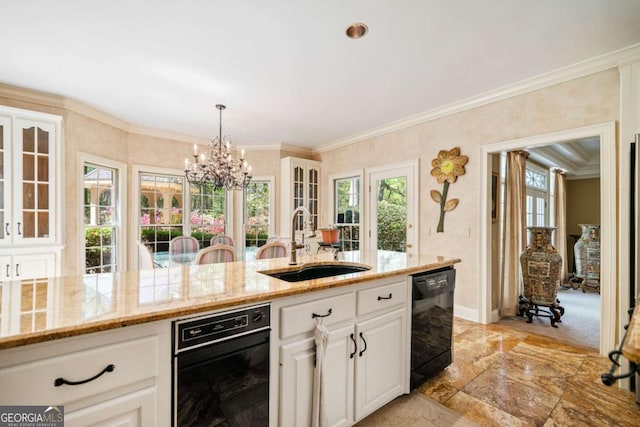 kitchen with white cabinets, black dishwasher, light stone counters, a sink, and a notable chandelier