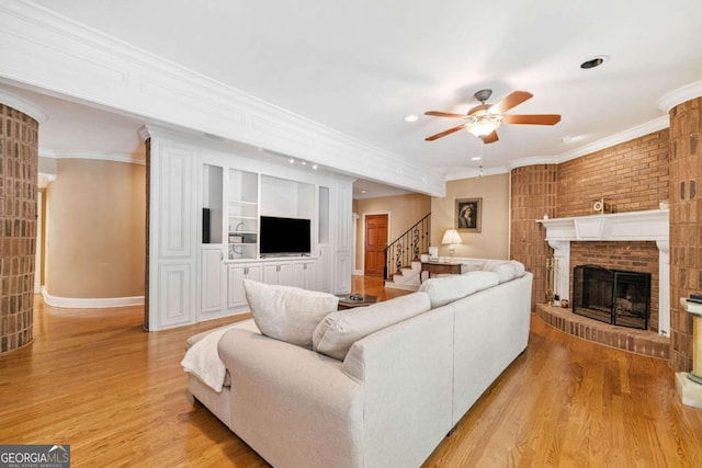 living area with ornamental molding, a ceiling fan, and light wood finished floors