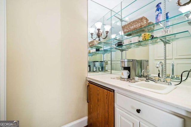 bar with an inviting chandelier, baseboards, and a sink