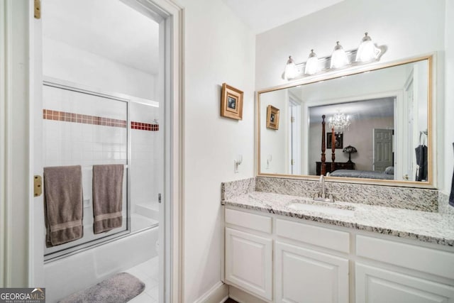 ensuite bathroom with bath / shower combo with glass door, vanity, and connected bathroom