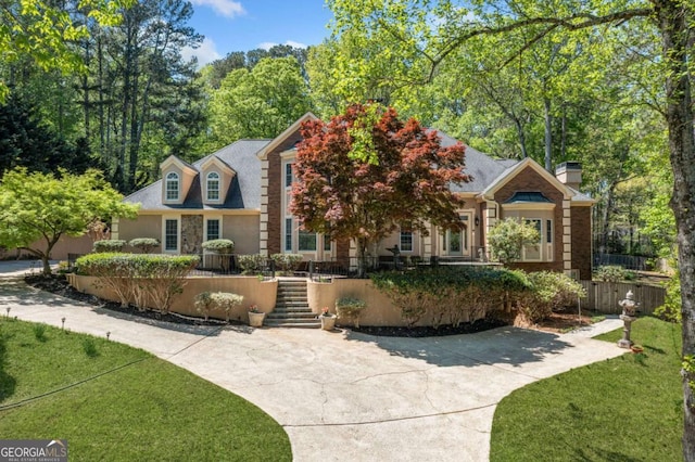 view of front of property featuring a front lawn, fence, and a chimney