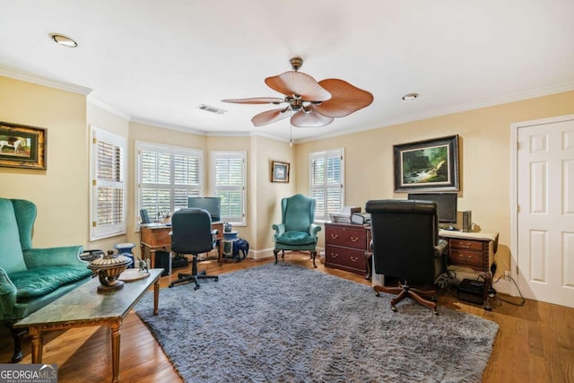 office space with crown molding, visible vents, a ceiling fan, and wood finished floors