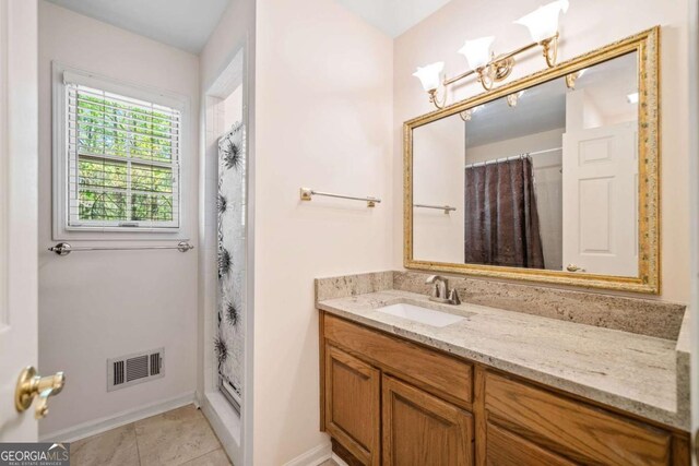 bathroom featuring visible vents, baseboards, a shower with curtain, vanity, and tile patterned floors
