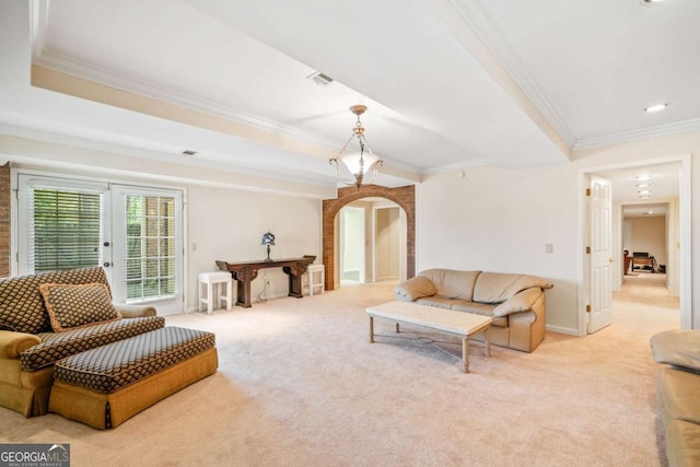 living room featuring visible vents, arched walkways, crown molding, french doors, and light carpet