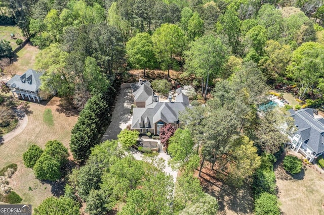 birds eye view of property featuring a view of trees