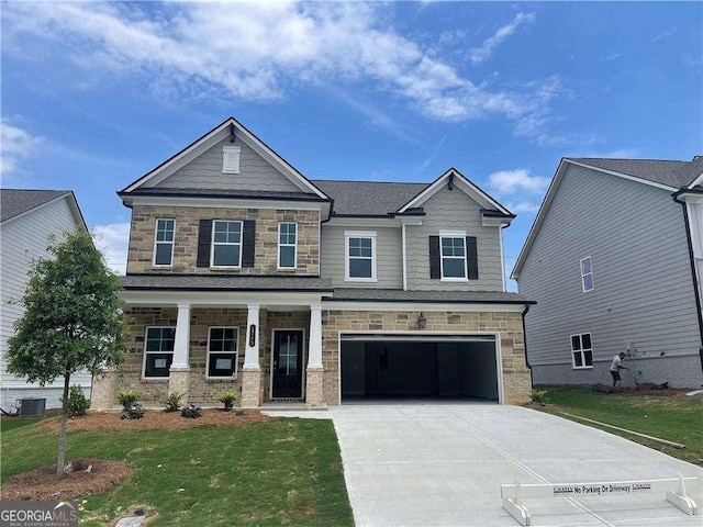 craftsman inspired home with a front yard, a porch, stone siding, a garage, and concrete driveway