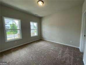 carpeted spare room featuring baseboards