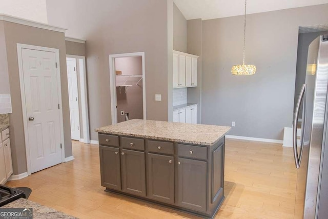 1910 Charleston Oak Cir, Lawrenceville, GA 30043 - kitchen with a chandelier, light wood finished floors, baseboards, and freestanding refrigerator