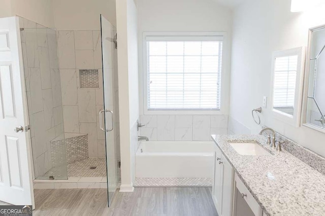 1910 Charleston Oak Cir, Lawrenceville, GA 30043 - bathroom featuring a stall shower, wood finished floors, vanity, and a garden tub