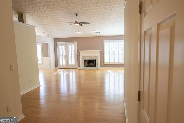 1910 Charleston Oak Cir, Lawrenceville, GA 30043 - unfurnished living room featuring light wood-type flooring, ceiling fan, a high end fireplace, and a wealth of natural light