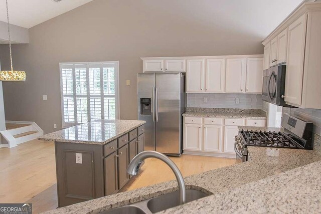 1910 Charleston Oak Cir, Lawrenceville, GA 30043 - kitchen with light stone counters, light wood-style flooring, decorative backsplash, stainless steel appliances, and a sink