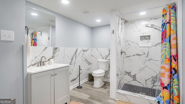 full bathroom with toilet, a marble finish shower, vanity, and recessed lighting