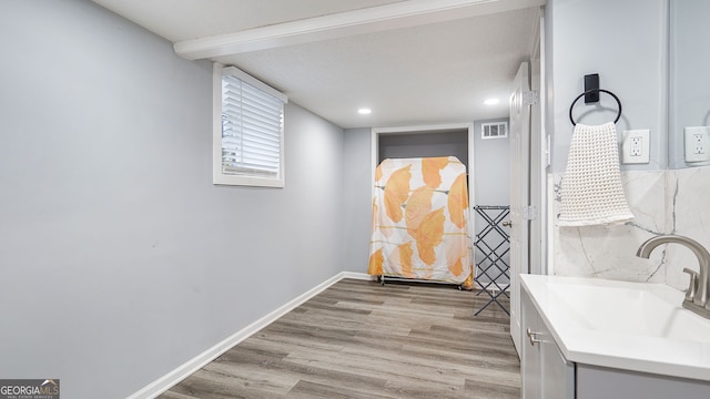 bathroom featuring vanity, baseboards, recessed lighting, visible vents, and wood finished floors