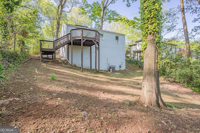 rear view of property with central air condition unit and a deck