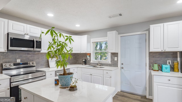kitchen with stainless steel appliances, recessed lighting, a sink, and a kitchen island