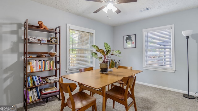 dining area with visible vents, baseboards, a ceiling fan, a textured ceiling, and carpet floors