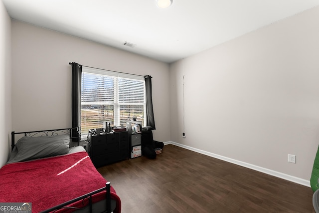 bedroom with dark wood-style flooring, baseboards, and visible vents