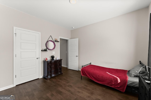 bedroom with baseboards and dark wood finished floors