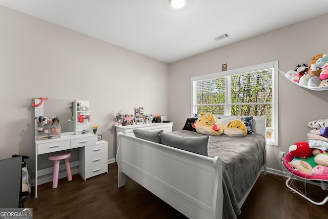 bedroom featuring wood finished floors, baseboards, and visible vents