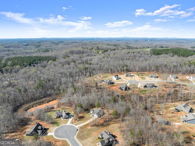 birds eye view of property with a view of trees