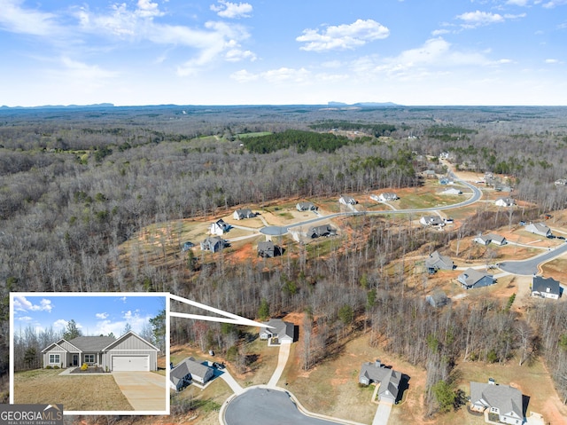 birds eye view of property with a wooded view