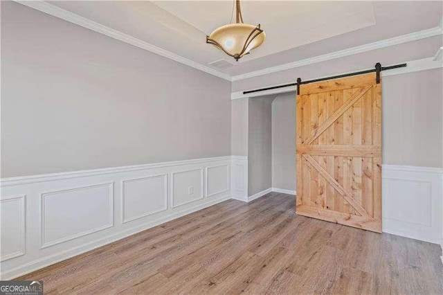 6655 Grove Meadows Ln, Cumming, GA 30028 - empty room with a decorative wall, a wainscoted wall, a barn door, and wood finished floors