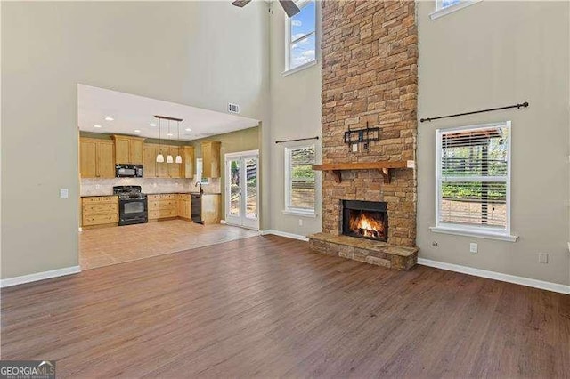 6655 Grove Meadows Ln, Cumming, GA 30028 - unfurnished living room featuring ceiling fan, a towering ceiling, baseboards, and wood finished floors