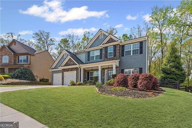 6655 Grove Meadows Ln, Cumming, GA 30028 - craftsman-style home with stone siding, driveway, a front yard, and fence