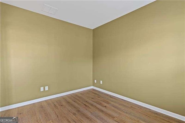 6655 Grove Meadows Ln, Cumming, GA 30028 - unfurnished room featuring lofted ceiling, visible vents, baseboards, and wood finished floors