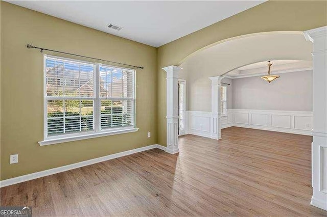 6655 Grove Meadows Ln, Cumming, GA 30028 - unfurnished room featuring arched walkways, wood finished floors, decorative columns, and visible vents