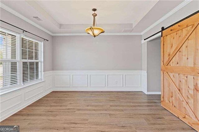 6655 Grove Meadows Ln, Cumming, GA 30028 - unfurnished room with a tray ceiling, light wood-type flooring, visible vents, and a barn door