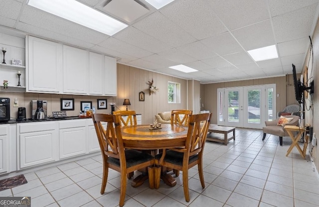 dining area with light tile patterned flooring, a drop ceiling, and plenty of natural light