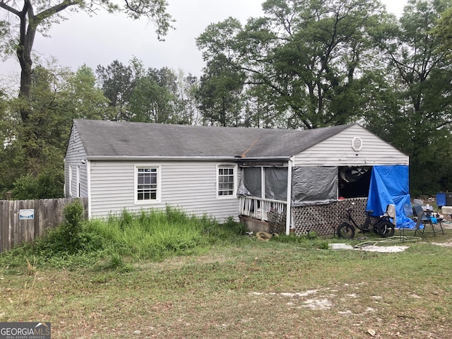 back of house with fence and a shingled roof