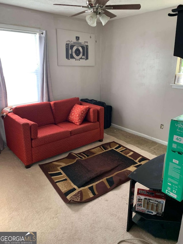 carpeted living area featuring ceiling fan