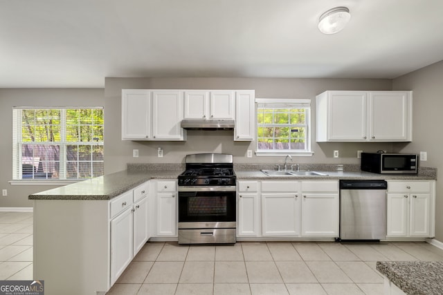 3571 Oakshire Way SE, Atlanta, GA 30354 - kitchen featuring white cabinets, a sink, appliances with stainless steel finishes, a peninsula, and under cabinet range hood