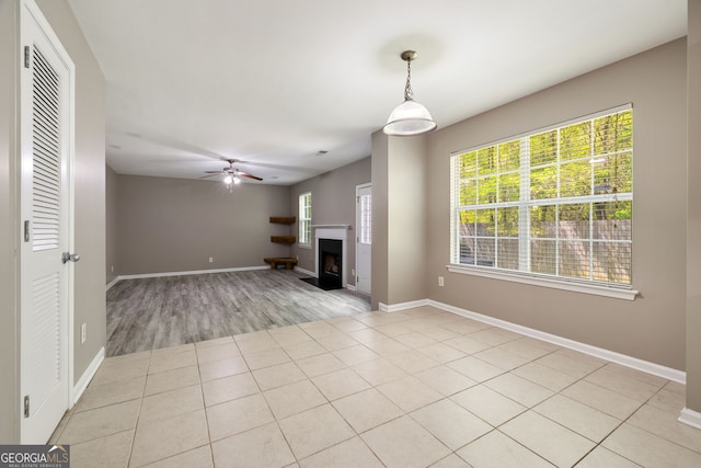 3571 Oakshire Way SE, Atlanta, GA 30354 - unfurnished living room with ceiling fan, a fireplace with raised hearth, light tile patterned flooring, and baseboards