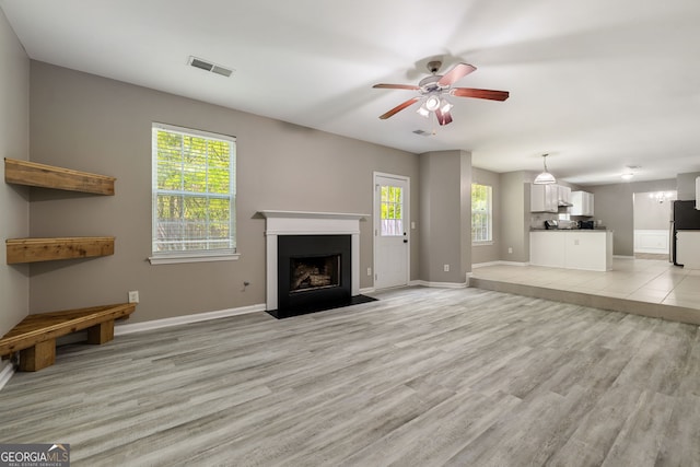 3571 Oakshire Way SE, Atlanta, GA 30354 - unfurnished living room with baseboards, light wood-style flooring, a fireplace with flush hearth, visible vents, and ceiling fan
