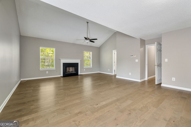 3571 Oakshire Way SE, Atlanta, GA 30354 - unfurnished living room featuring a ceiling fan, wood finished floors, vaulted ceiling, and a fireplace with flush hearth