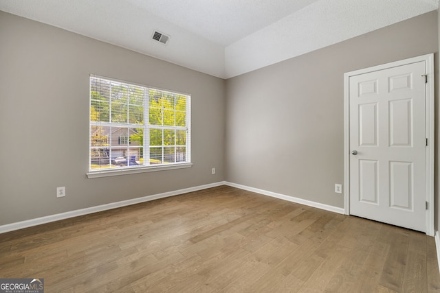 3571 Oakshire Way SE, Atlanta, GA 30354 - empty room featuring lofted ceiling, visible vents, baseboards, and wood finished floors