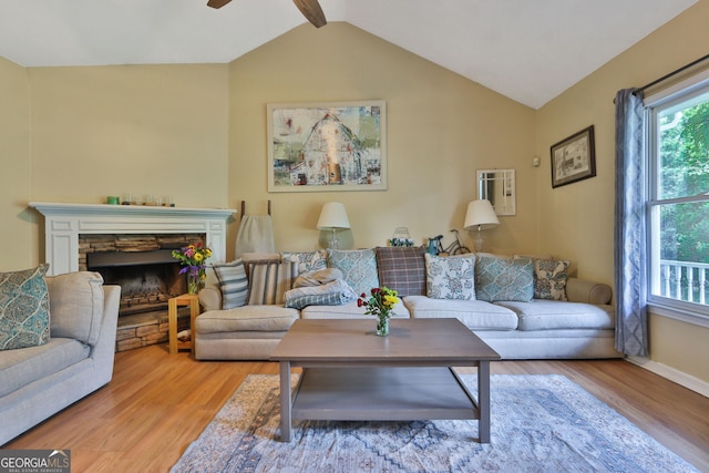 2675 Dacula Ridge Dr, Dacula, GA 30019 - living area with wood finished floors, vaulted ceiling, ceiling fan, and a stone fireplace